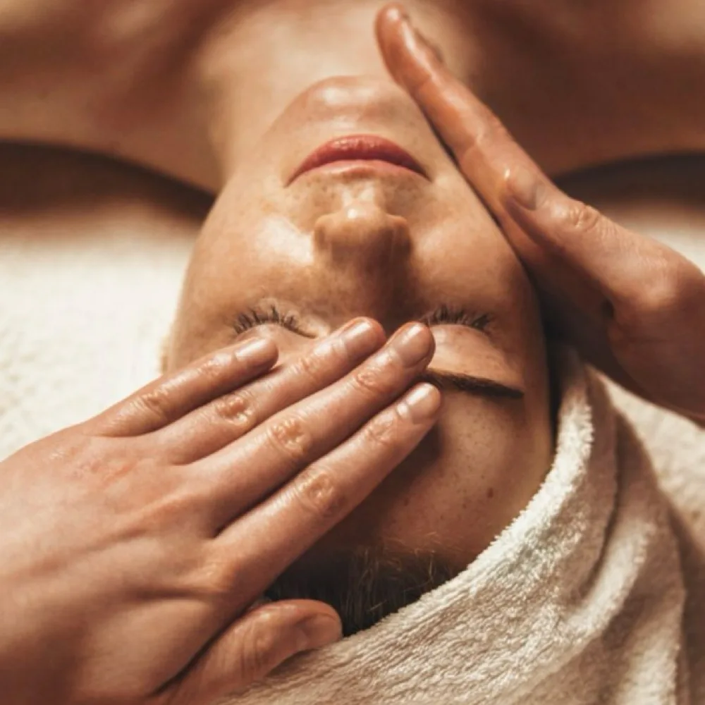 A client receiving the No Tox lymphatic and sculpting facial with a relaxing massage technique.